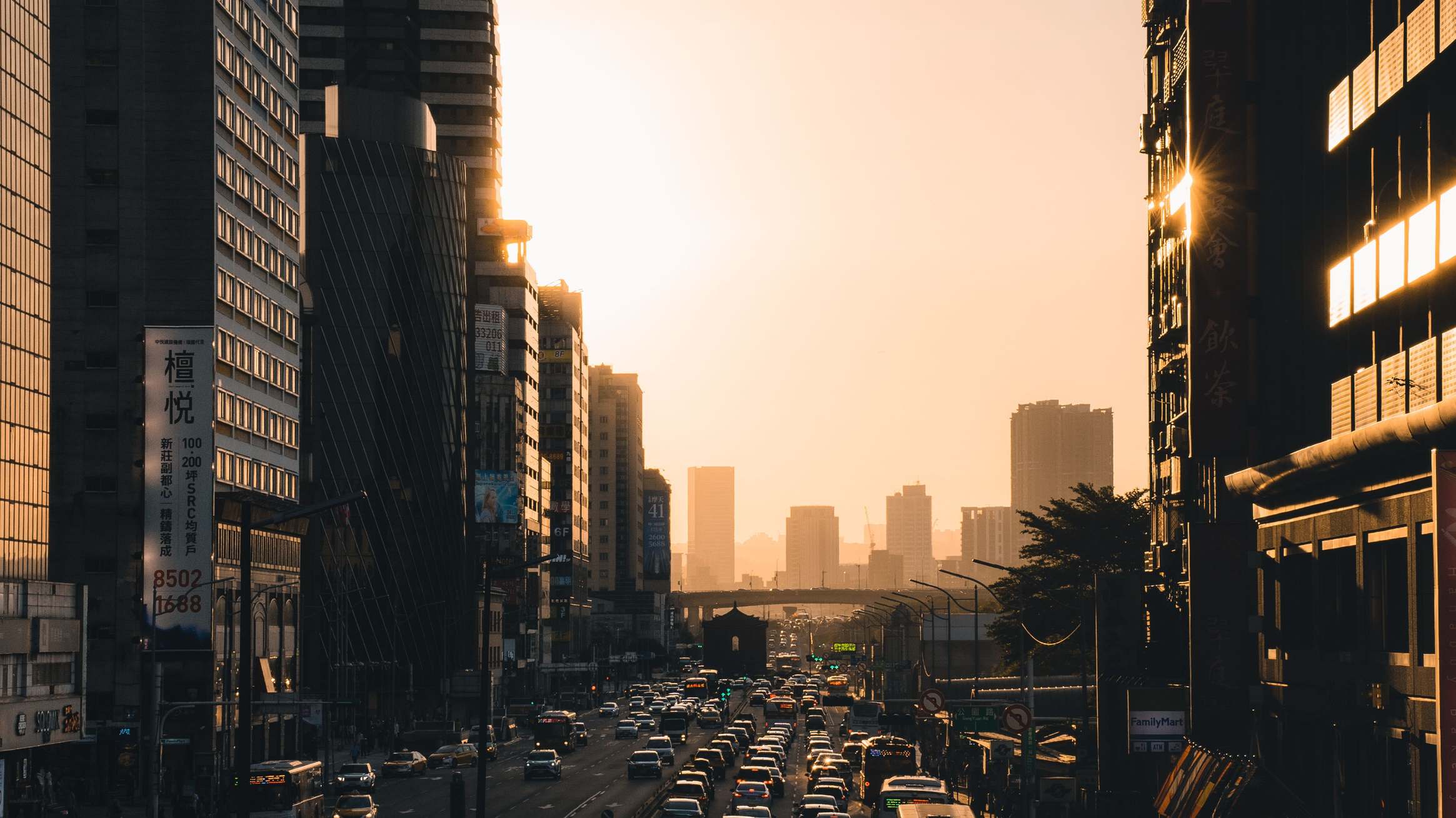 Urban office district with modern buildings along a city street during sunset with busy streets and skyscrapers